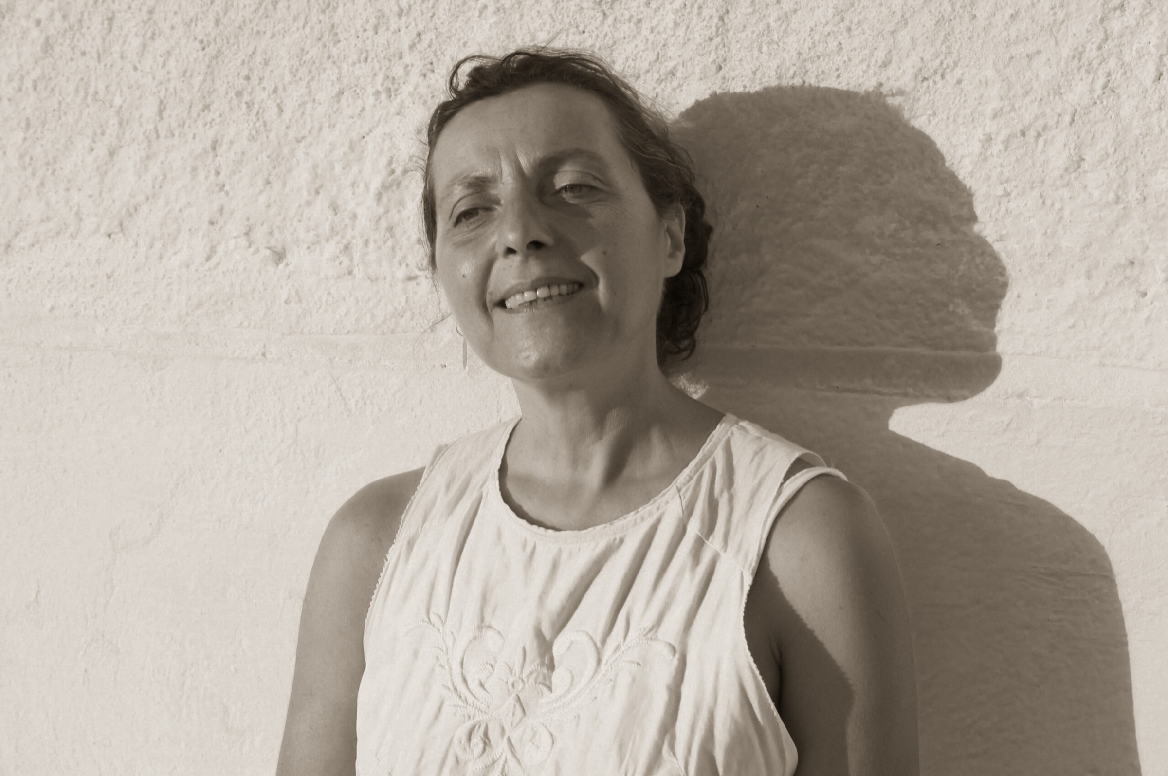 Katerina Panagiotopoulou smiling against a sunlit white wall